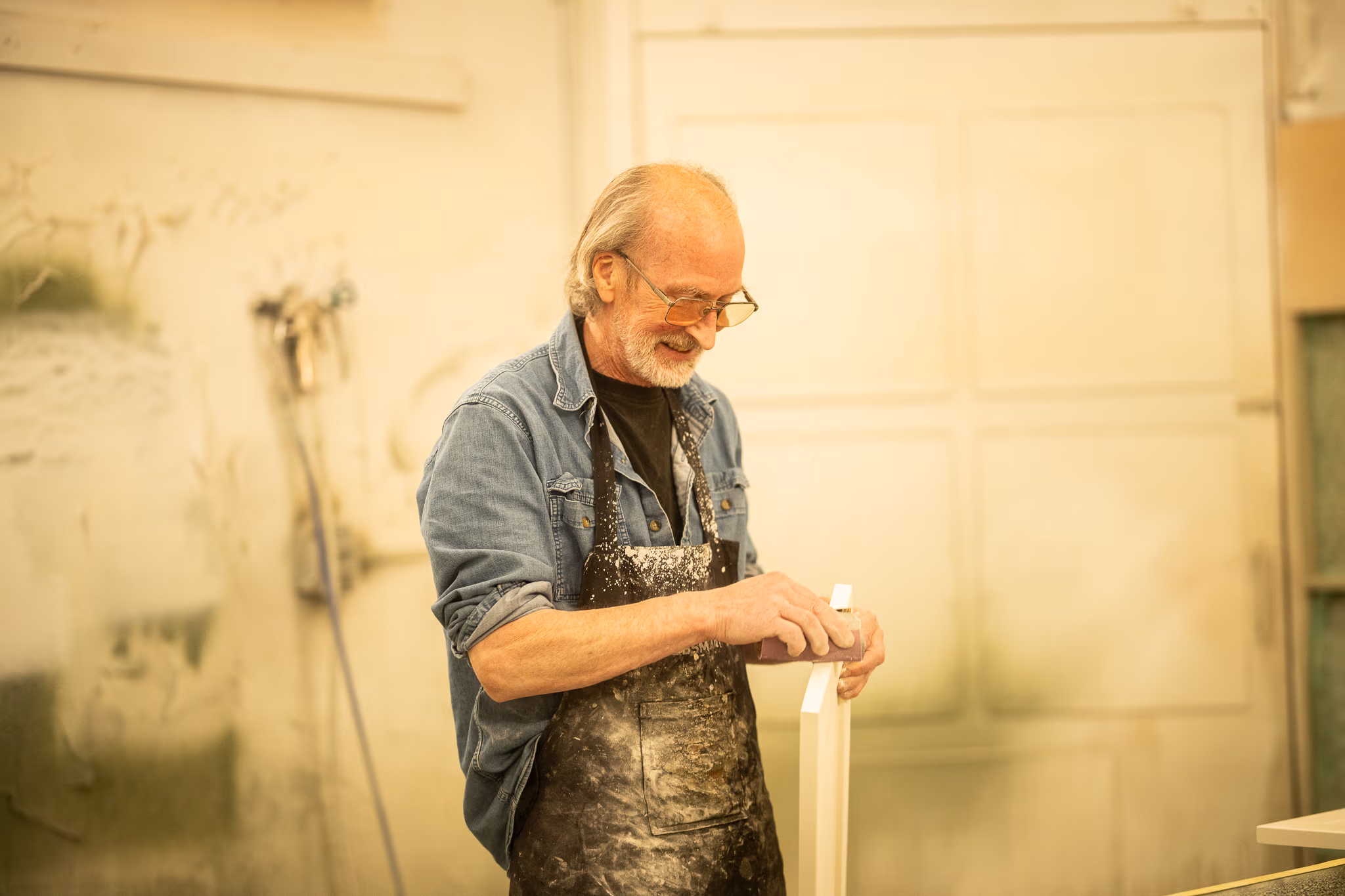 a man working on a cabinet door